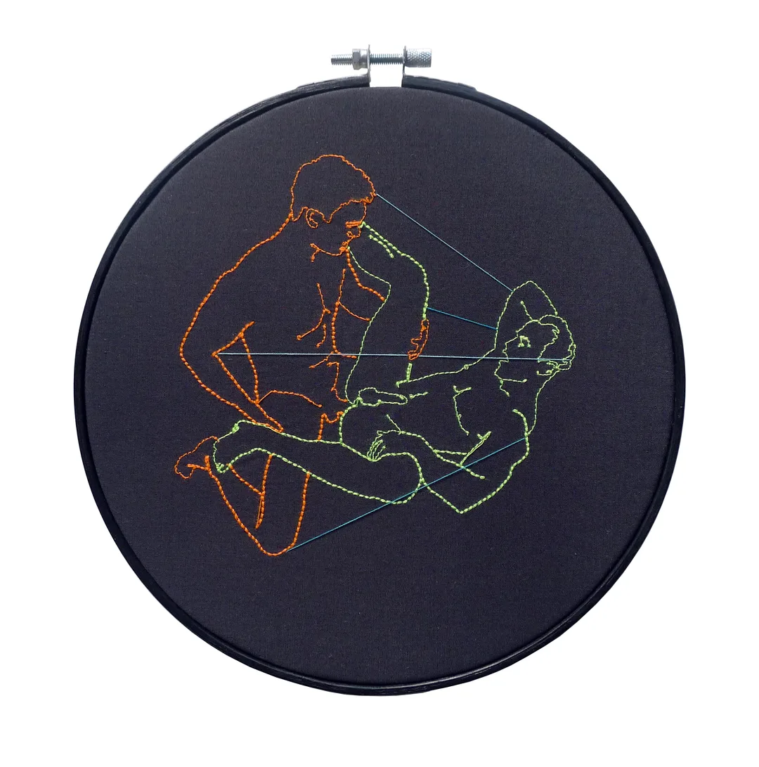 Embroidery in neon orange and yellow displayed in black embroidery hoop